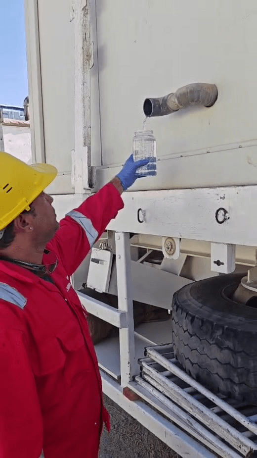 Operator drawing treated water at the outlet of a containerised unit